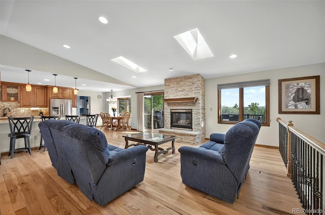 723 Orion Dr, Colorado Springs, CO 80906 - living area with lofted ceiling, a skylight, a fireplace, light wood-style floors, and recessed lighting