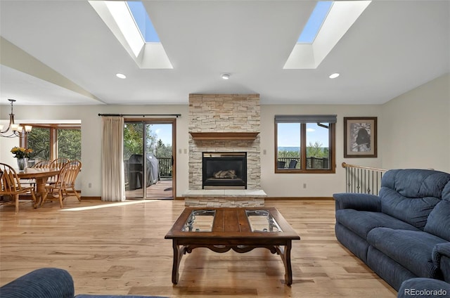 723 Orion Dr, Colorado Springs, CO 80906 - living area featuring a skylight, a chandelier, light wood finished floors, a fireplace, and lofted ceiling