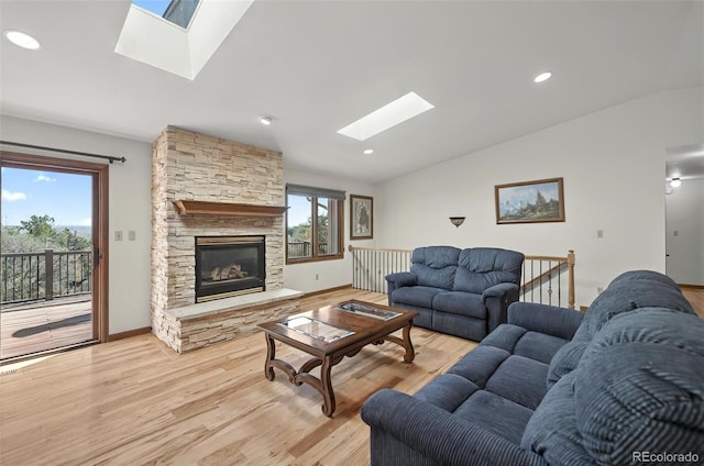 723 Orion Dr, Colorado Springs, CO 80906 - living room featuring a skylight, lofted ceiling, light wood-type flooring, a fireplace, and recessed lighting