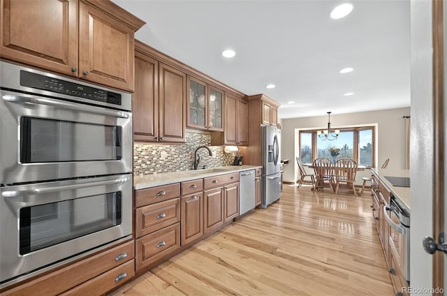 723 Orion Dr, Colorado Springs, CO 80906 - kitchen with a sink, appliances with stainless steel finishes, brown cabinetry, light wood-type flooring, and recessed lighting