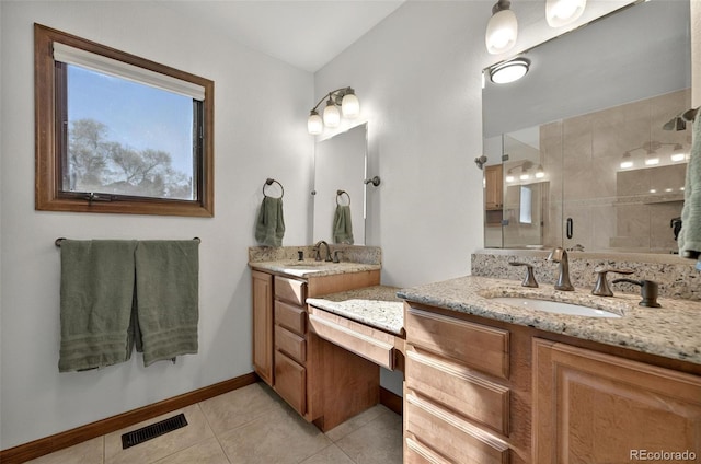 723 Orion Dr, Colorado Springs, CO 80906 - bathroom featuring two vanities, a stall shower, tile patterned flooring, and baseboards