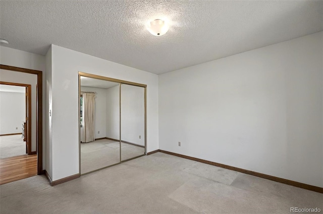 723 Orion Dr, Colorado Springs, CO 80906 - unfurnished bedroom with light carpet, a closet, baseboards, and a textured ceiling