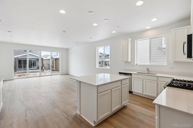 kitchen featuring appliances with stainless steel finishes, a center island, sink, and white cabinets