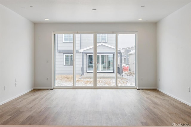 spare room with plenty of natural light and light hardwood / wood-style flooring