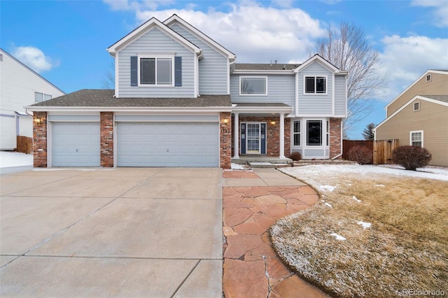 view of front of home featuring brick siding, fence, and driveway