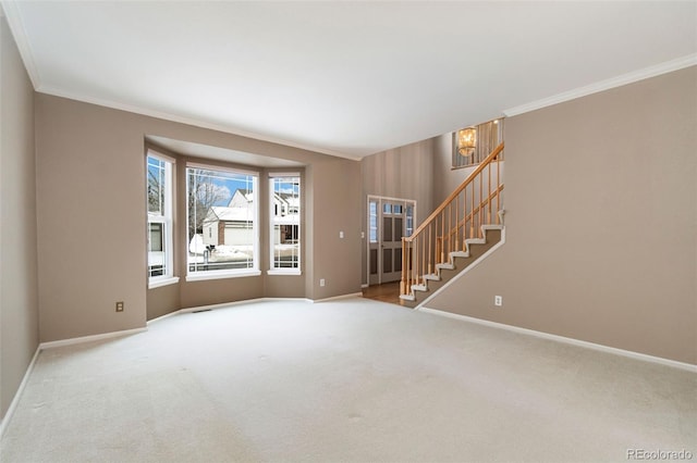 carpeted spare room featuring ornamental molding, stairway, and baseboards