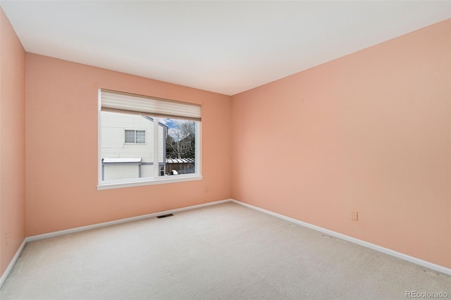 carpeted empty room featuring visible vents and baseboards