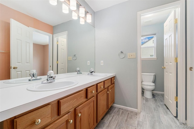 full bath with double vanity, a sink, and toilet