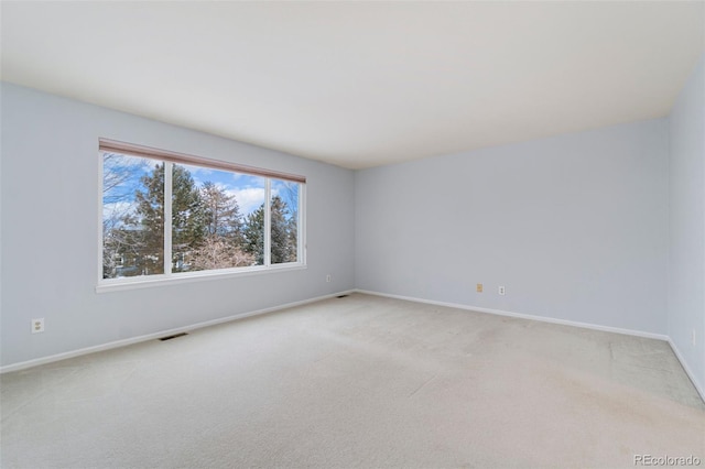 unfurnished room with light carpet, visible vents, and baseboards