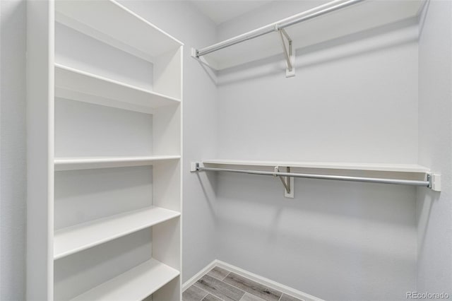 walk in closet with wood finished floors