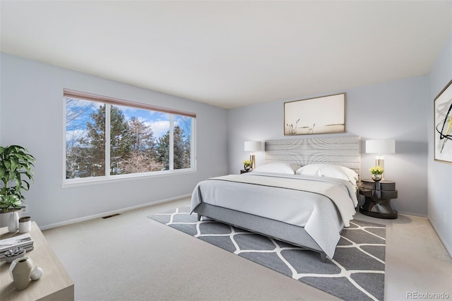 bedroom featuring baseboards, visible vents, and light colored carpet