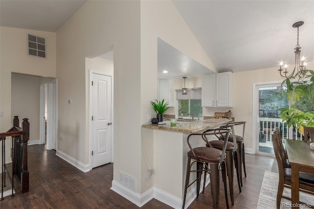10370 Routt St, Westminster, CO 80021 - kitchen with high vaulted ceiling, white cabinetry, dark wood-style flooring, baseboards, and a chandelier