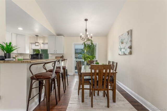 10370 Routt St, Westminster, CO 80021 - dining area with baseboards, dark wood finished floors, and a chandelier