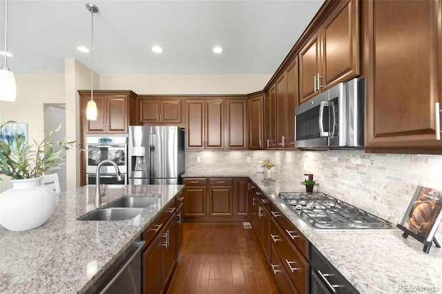 15779 W 83rd Pl, Arvada, CO 80007 - kitchen with appliances with stainless steel finishes, a sink, dark wood-style flooring, light stone countertops, and pendant lighting