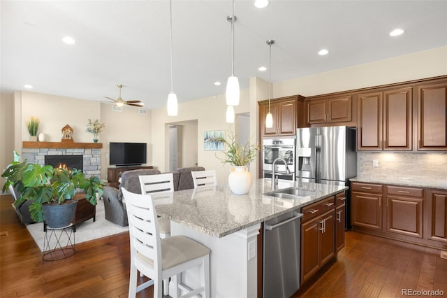 15779 W 83rd Pl, Arvada, CO 80007 - kitchen featuring a sink, stainless steel appliances, dark wood-style flooring, a kitchen bar, and recessed lighting
