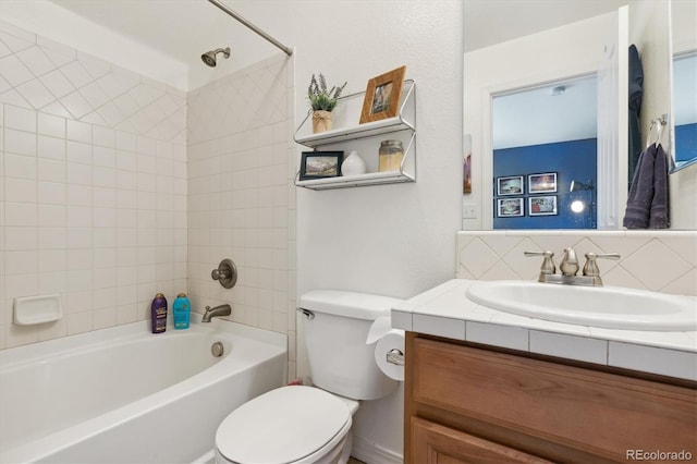 full bathroom featuring tiled shower / bath combo, vanity, toilet, and tasteful backsplash