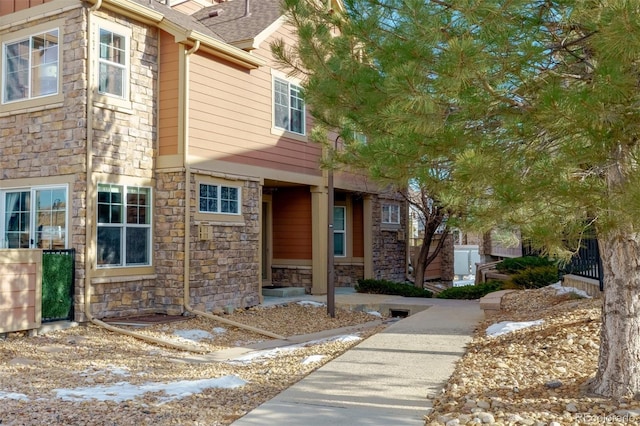 view of front of home with stone siding and a shingled roof