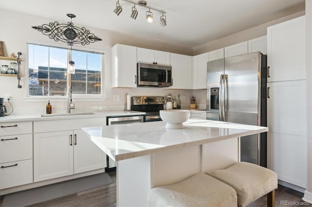 kitchen with hanging light fixtures, white cabinetry, appliances with stainless steel finishes, and a center island