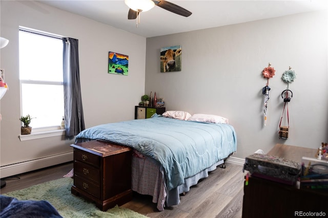 bedroom with ceiling fan, a baseboard radiator, light wood-style flooring, and baseboards