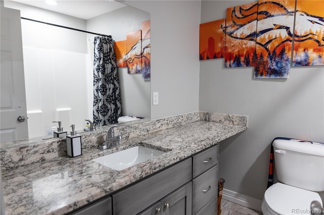 bathroom featuring curtained shower, toilet, vanity, baseboards, and tile patterned floors