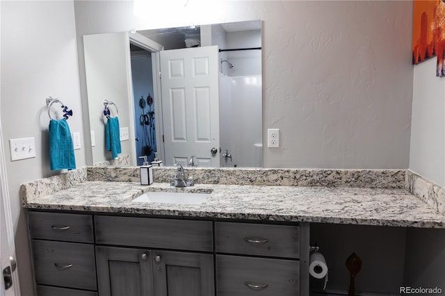 bathroom with a textured wall and vanity