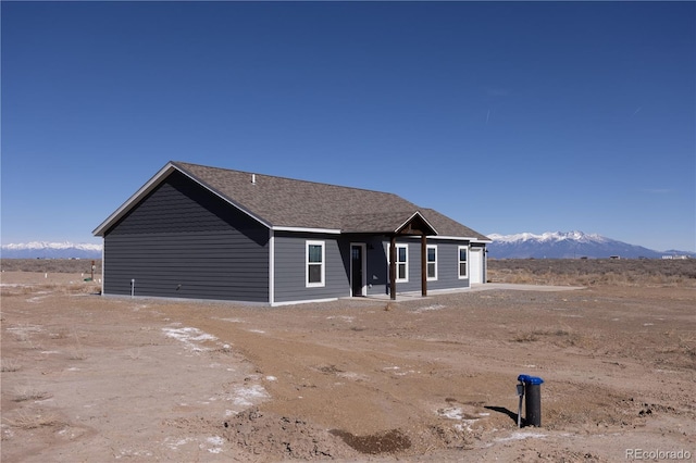 view of front of house featuring roof with shingles and a mountain view