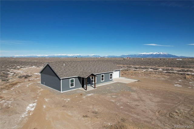 view of front facade with a patio area, a mountain view, and driveway