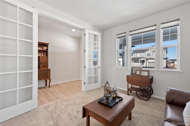 living area with french doors and light colored carpet