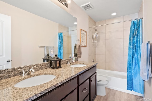 full bathroom with hardwood / wood-style flooring, vanity, toilet, and shower / bath combo with shower curtain