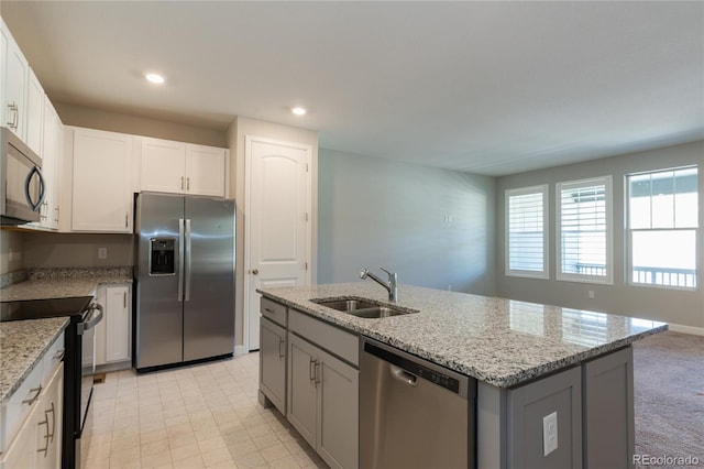 kitchen with white cabinets, a center island with sink, appliances with stainless steel finishes, and sink