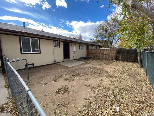 rear view of house with a patio area and a fenced backyard