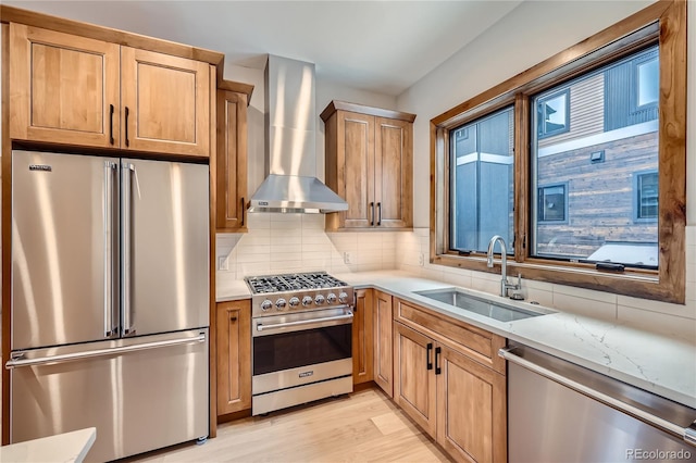 308 Creekside Aly Unit 5, Frisco, CO 80443 - kitchen featuring premium appliances, wall chimney range hood, tasteful backsplash, light wood-type flooring, and light stone countertops