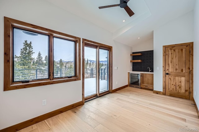 308 Creekside Aly Unit 5, Frisco, CO 80443 - unfurnished living room featuring wine cooler, vaulted ceiling, bar, a ceiling fan, and light wood-type flooring