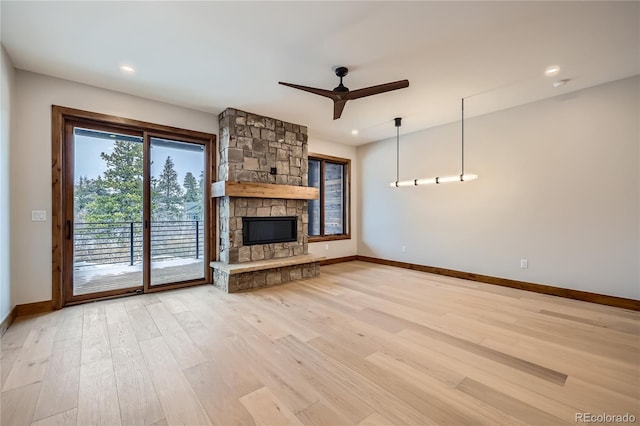308 Creekside Aly Unit 5, Frisco, CO 80443 - unfurnished living room featuring light wood-style flooring, a ceiling fan, a stone fireplace, and recessed lighting