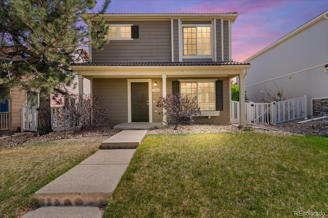 21562 E 47th Ave, Denver, CO 80249 - traditional-style house with covered porch, fence, and a front lawn