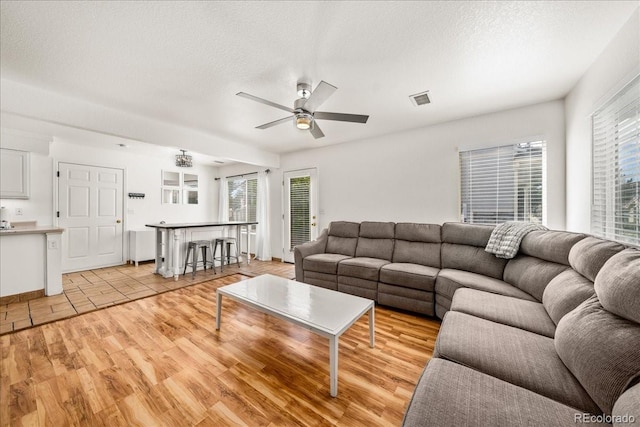 21562 E 47th Ave, Denver, CO 80249 - living area featuring light wood finished floors, ceiling fan, a textured ceiling, and visible vents