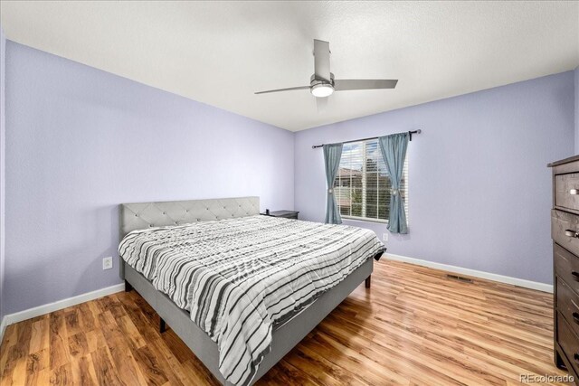 21562 E 47th Ave, Denver, CO 80249 - bedroom with baseboards, a ceiling fan, visible vents, and wood finished floors