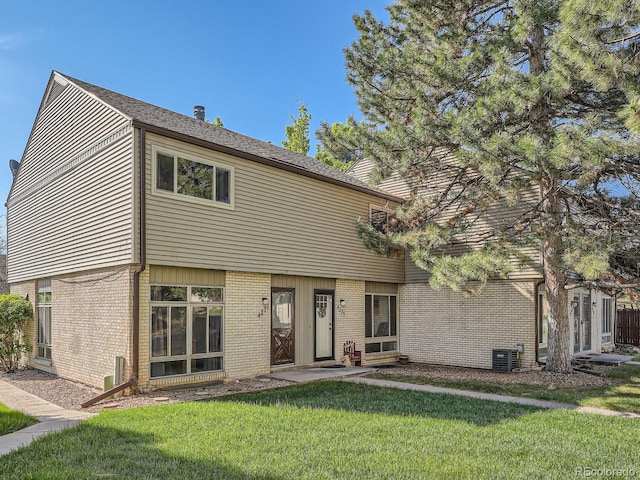4273 W Ponds Cir, Littleton, CO 80123 - view of front of home with brick siding, a front yard, and cooling unit