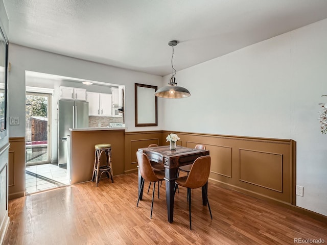 4273 W Ponds Cir, Littleton, CO 80123 - dining room with light wood-style flooring and wainscoting