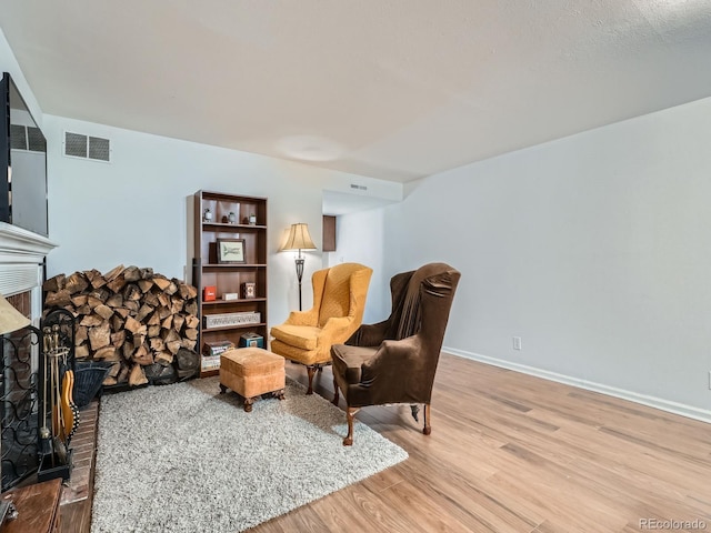 4273 W Ponds Cir, Littleton, CO 80123 - living area featuring a fireplace, wood finished floors, and baseboards