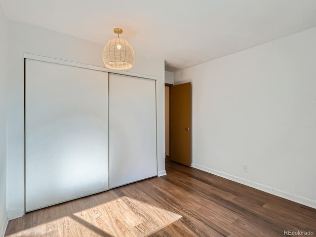 4273 W Ponds Cir, Littleton, CO 80123 - unfurnished bedroom with a closet, wood finished floors, and baseboards