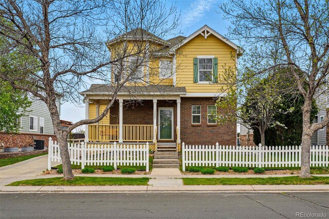 14025 Blue River Trl, Broomfield, CO 80023 - view of front of property featuring covered porch, brick siding, driveway, and a fenced front yard