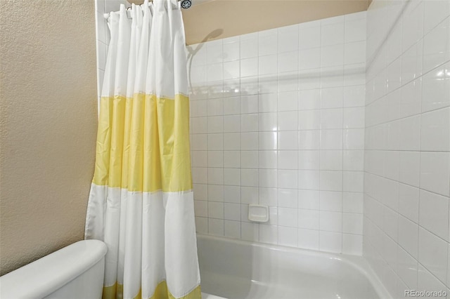 14025 Blue River Trl, Broomfield, CO 80023 - bathroom featuring toilet, a textured wall, and shower / bath combo