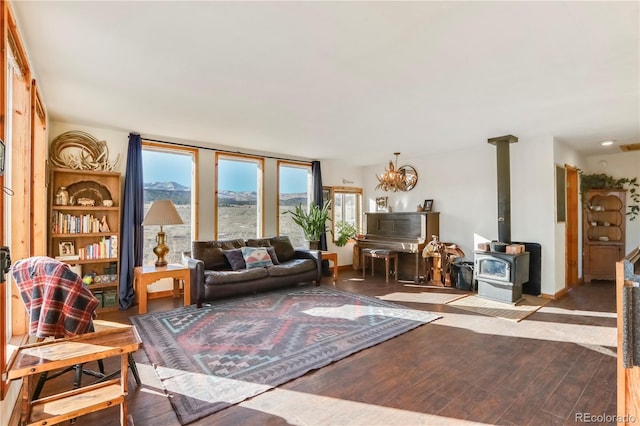 living room featuring an inviting chandelier, a wood stove, and light hardwood / wood-style flooring