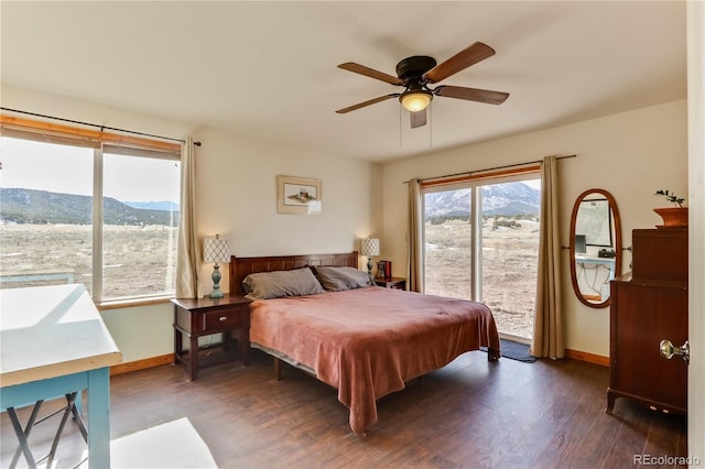 bedroom featuring a mountain view, access to exterior, ceiling fan, and dark wood-type flooring