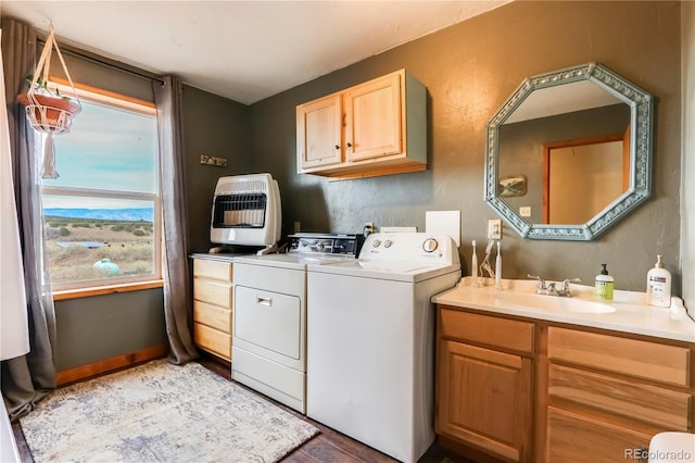 clothes washing area featuring cabinets, heating unit, washer and clothes dryer, sink, and light hardwood / wood-style floors