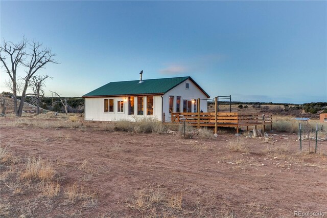 rear view of property featuring a wooden deck and a rural view