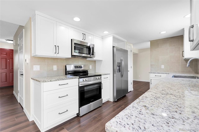 3653 E 133rd Ct, Thornton, CO 80241 - kitchen with appliances with stainless steel finishes, a sink, backsplash, light stone countertops, and dark wood finished floors
