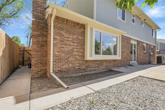 3653 E 133rd Ct, Thornton, CO 80241 - view of side of home featuring fence, central air condition unit, a chimney, and brick siding