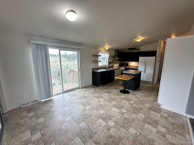 1326 Kaufman Rd, Hartsel, CO 80449 - kitchen with freestanding refrigerator, light stone finish floors, a kitchen island, a sink, and dark cabinetry